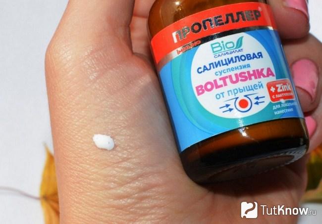 Баночка с болтушкой от прыщей в руке