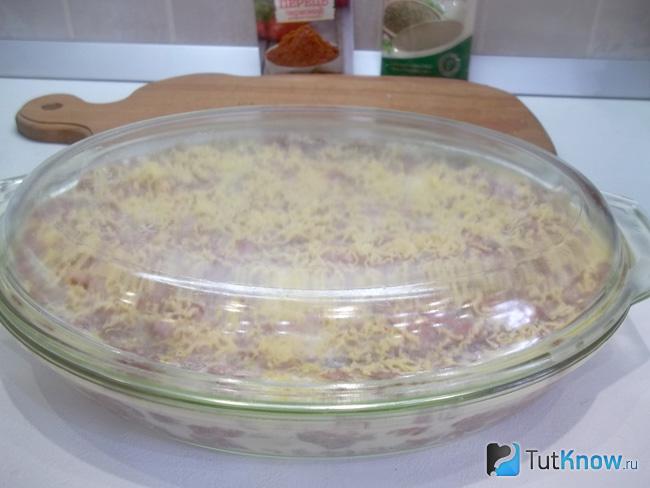 Картофельный гратен с мясом закрыт крышкой и отправлен в духовку