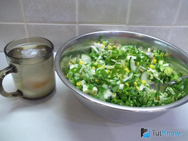 Готовый салат из молодой капусты, кукурузы, черемши и яйца пашот