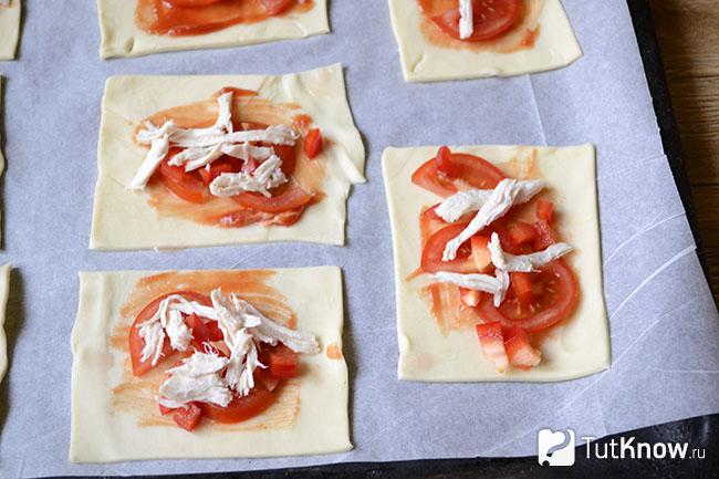 Кусочки куриного филе выложены поверх помидоров