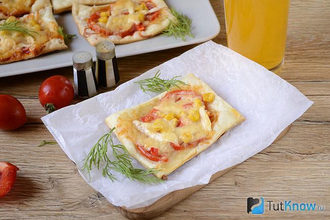 Мини-пицца из слоеного теста с курицей и кукурузой готова к употреблению