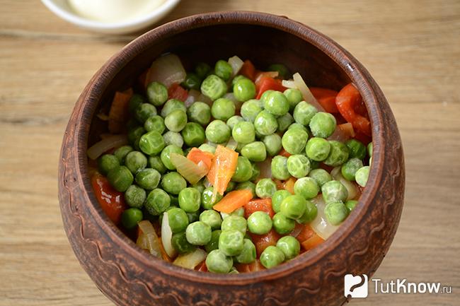 Лук, морковь, перец и горошек выложены поверх куриных сердечек