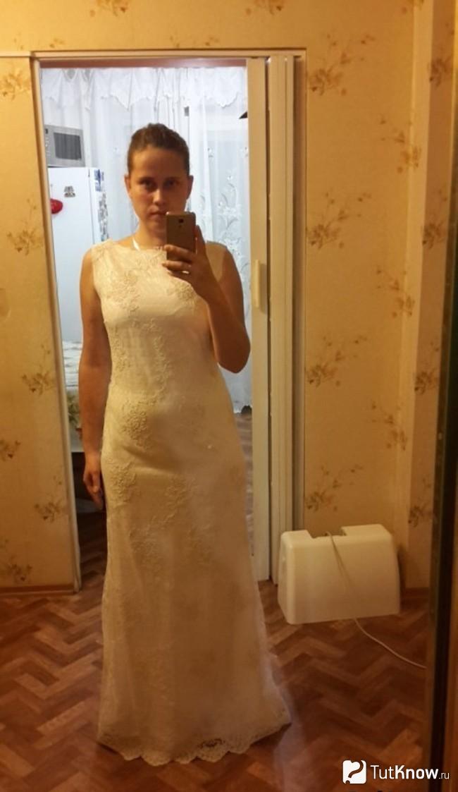 Девушка в свадебном платье перед зеркалом