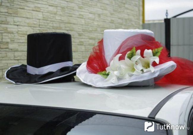 Черная и белая шляпа на крыше свадебного авто