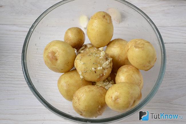 Клубни картофеля обработаны чесноком и розмарином