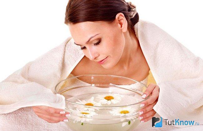 Женщина перед ванночкой с ромашкой