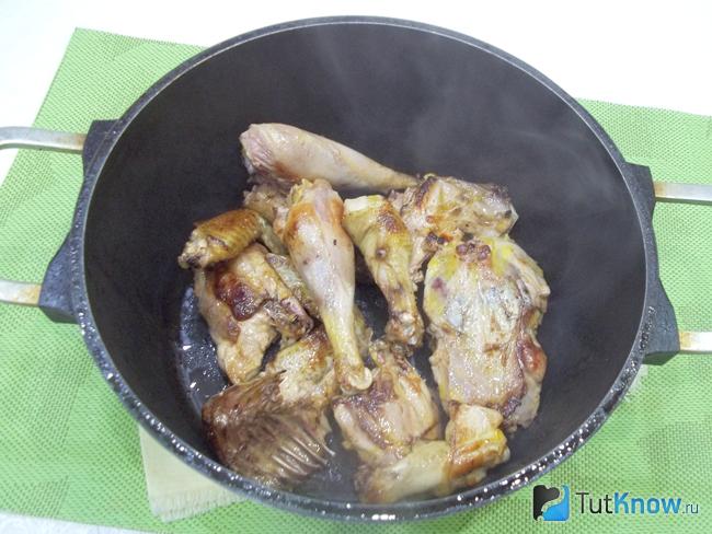 Жареные кусочки курицы сложены в кастрюлю