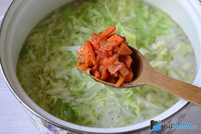 Ложка зажарки над кастрюлей с бульоном