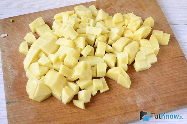 Нарезанная картошка на кухонной доске