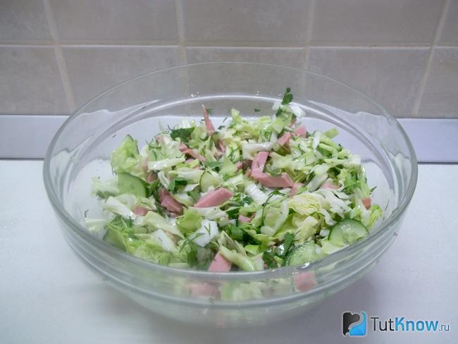 Готовый салат с капустой, огурцами и колбасой