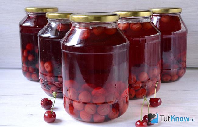 Банки с готовым компотом из ягод вишни и смородины