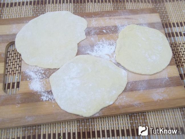 Кусочки теста для вареников с вишнями раскатаны скалкой