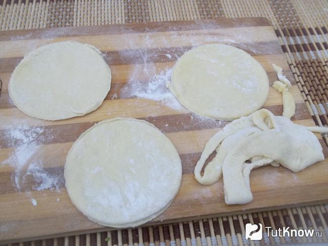 Из листов теста вырезаны круглые формы , лишнее тесто убрано
