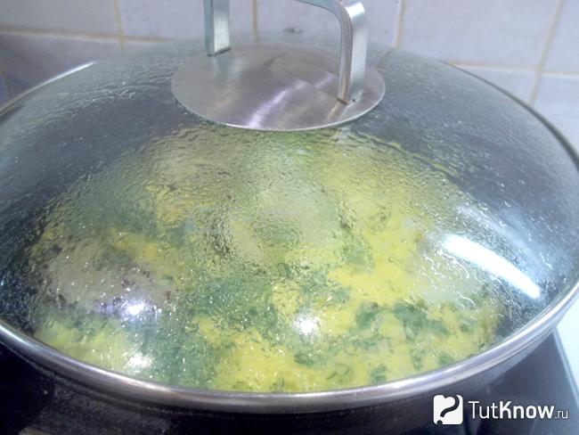 Омлет на молоке с жареными кабачками готовится в сковороде под крышкой