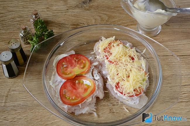 Кусок помидора и тёртый сыр поверх мяса