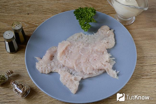 Куски сырого куриного филе на тарелке