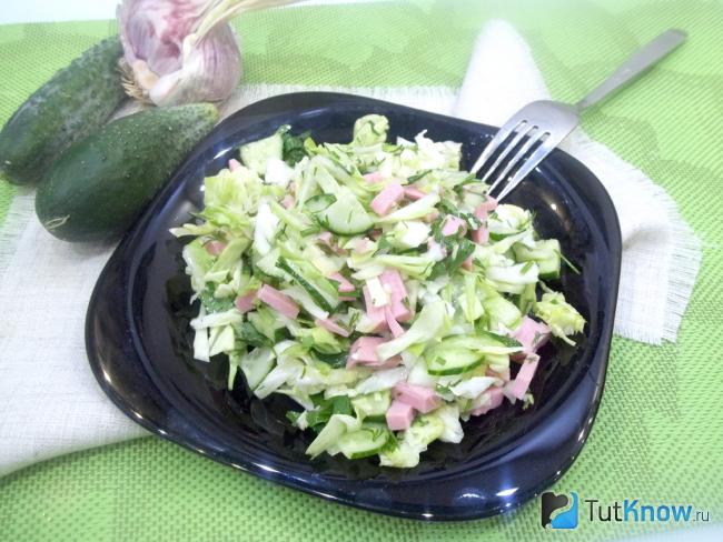Готовый салат с капустой, огурцами и колбасой