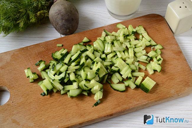 Нарезанные огурцы на кухонной доске