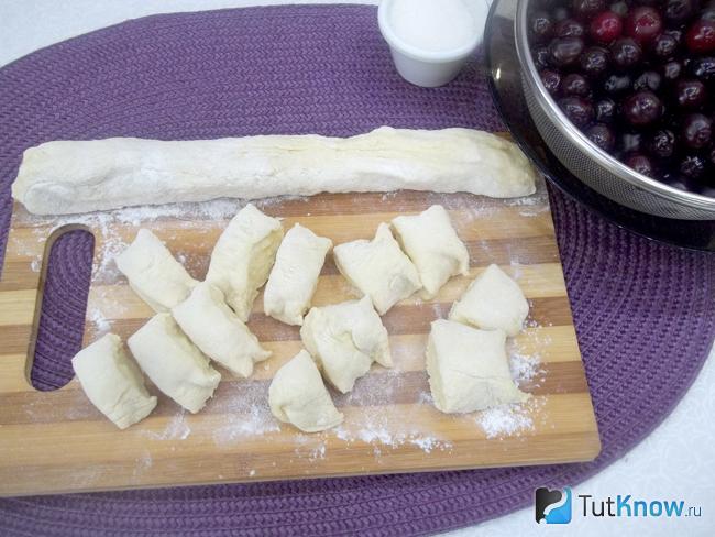 Тесто раскатано колбаской и разрезано на порционные куски