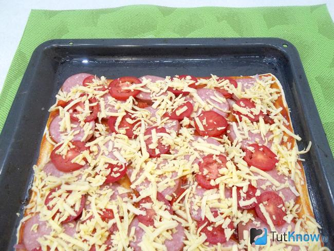Тесто присыпано сырной стружкой