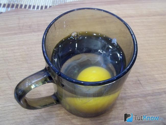 Яйцо опущено в чашку с водой