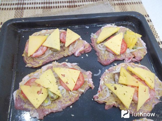 Мясо присыпано сыром и отправлено в духовку