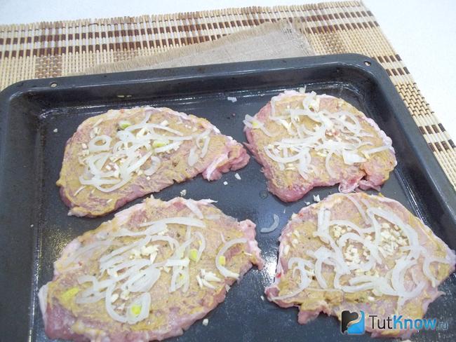На мясо выложен мелко рубленый лук