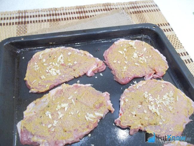 На мясо выложен мелко рубленый чеснок