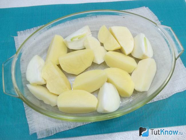 Картофель и лук очищены, нарезаны дольками и выложены в форму для запекания