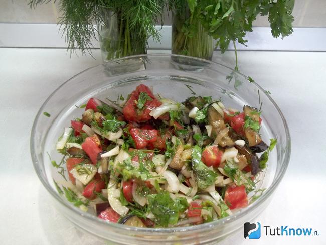 Салат из свежих помидоров и жареных баклажанов заправлен маслом, солью и перемешан