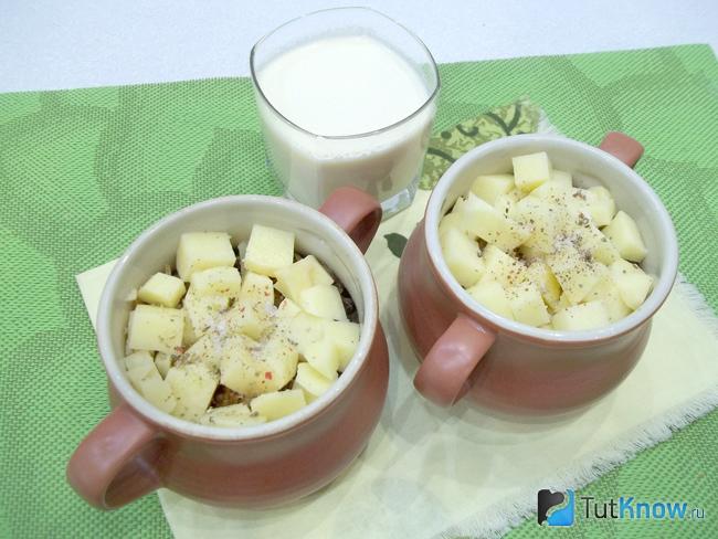 В горшочки добавлен картофель и продукты залиты молоком