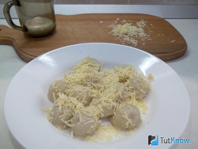 Пельмени присыпаны сырной стружкой
