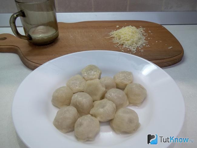 Отваренные пельмени выложены на тарелку