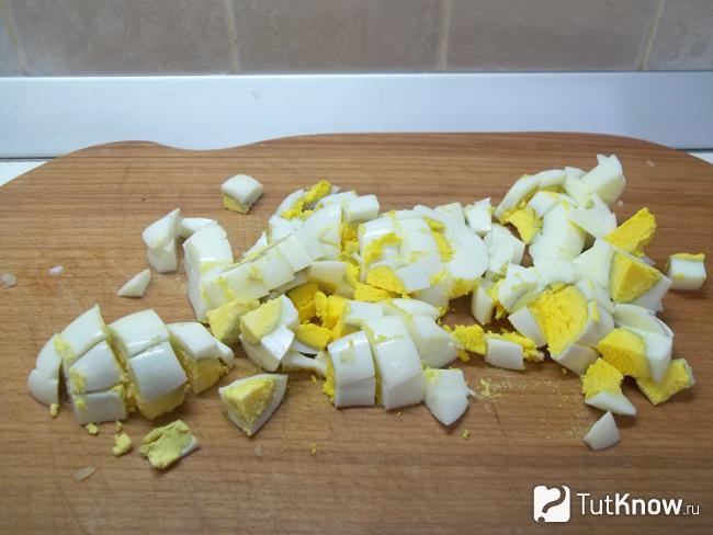 Отваренные яйца очищены и нарезаны кубиками