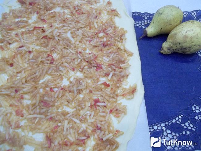 Тесто раскатано и выложены яблоки натертые на терке