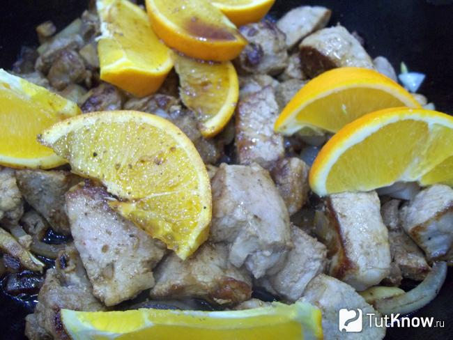 К мясу в сковороду добавлен нарезанный дольками апельсин