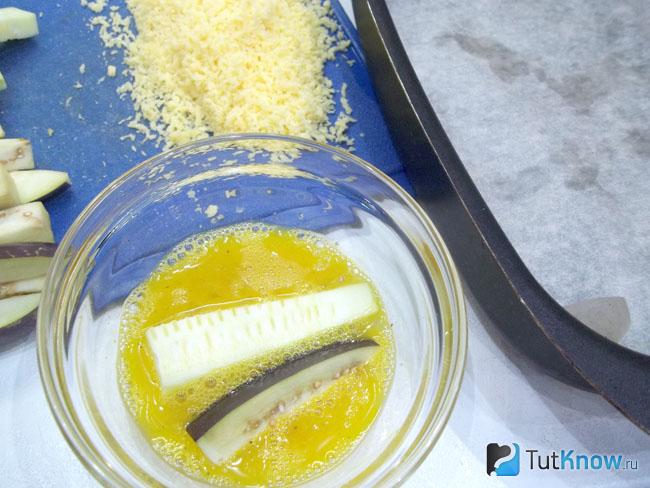 Яйца взбиты и в миску опущены баклажаны с кабачками