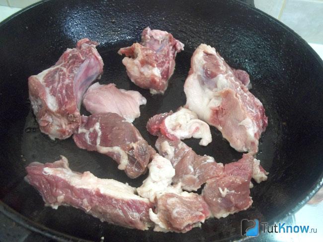 Мясо нарезано кусочками и жарится в сковороде