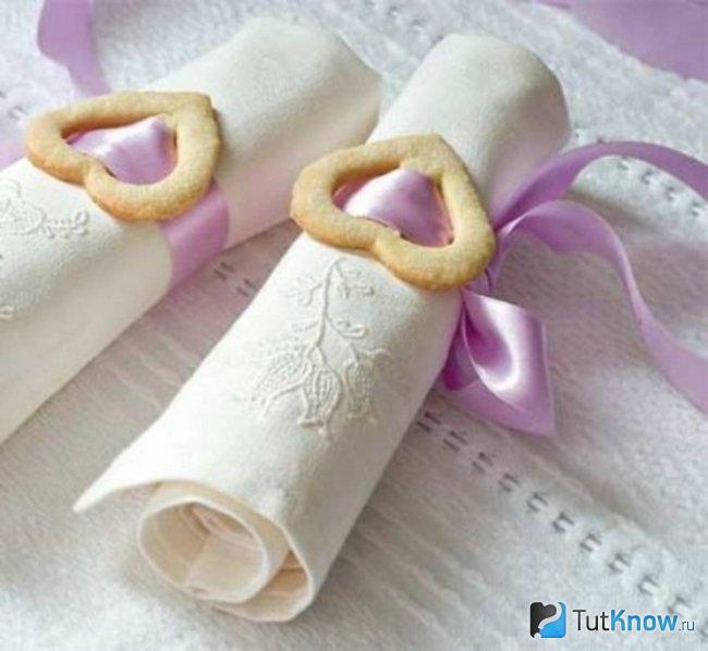 Белые льняные салфетки, обмотанные атласной лентой