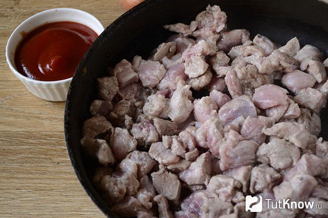 Кусочки мяса на сковороде