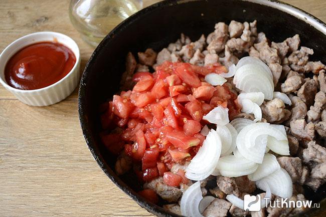 Резаные помидоры и лук добавлены к мясу