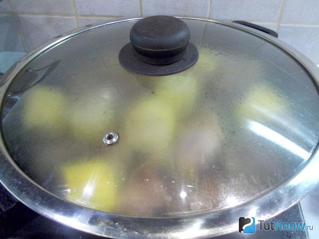 Кукуруза с курицей тушатся в сковороде под крышкой