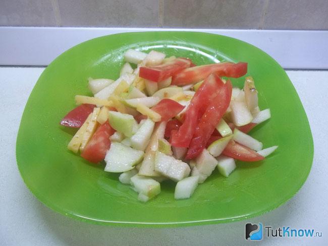 Готовый салат с помидорами, яблоками, грушей и сыром