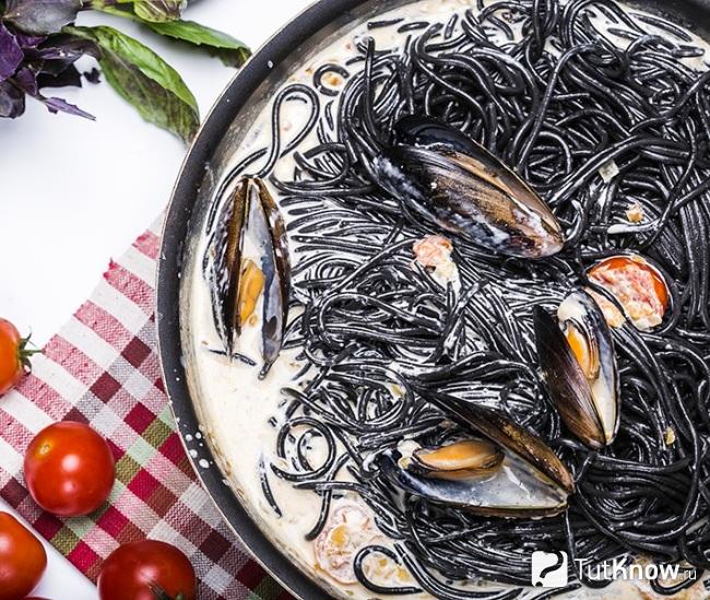 Черная паста с мидиями и овощами под сыром Дорблю