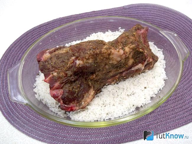 Рис выложен в форму для запекания и сверху расположено мясо