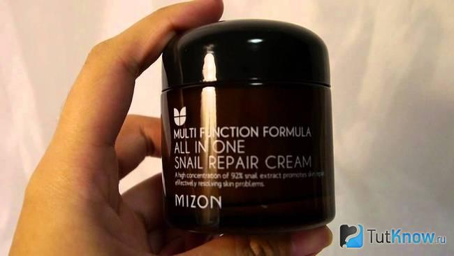 Баночка с косметическим средством Mizon all one snall в руке
