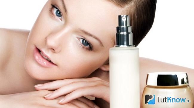 Флаконы с косметическими средствами стоят перед девушкой