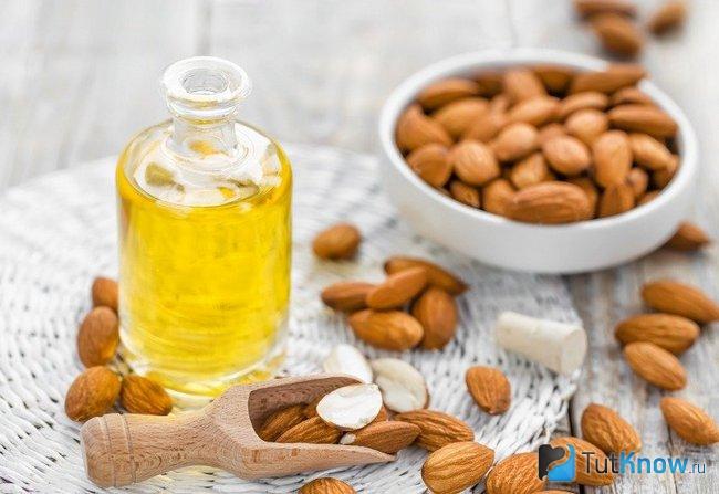 Ядра миндаля и бутылка с миндальным маслом