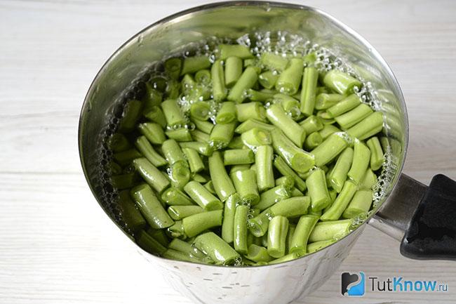 Кусочки стручковой фасоли варятся в воде