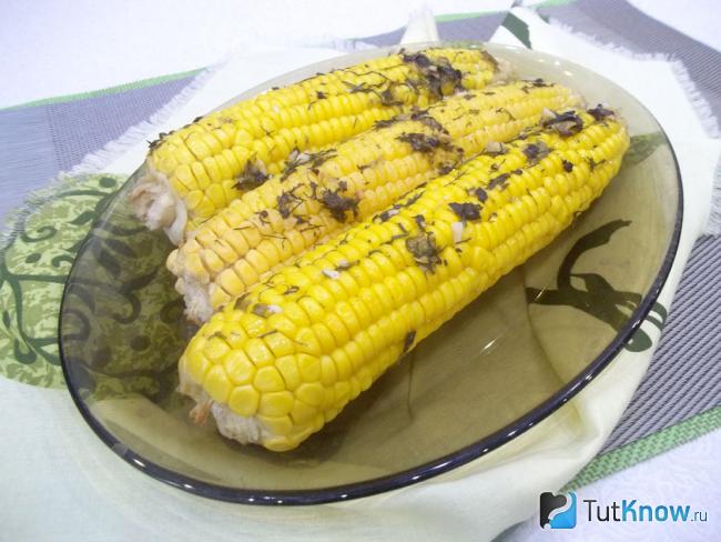 Готовая печеная кукуруза в духовке с маслом, чесноком и специями